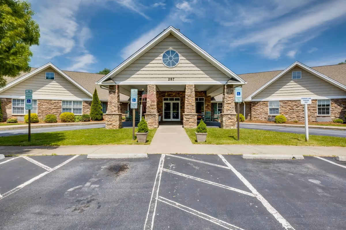 Front view of Deerfield Ridge Assisted Living entrance with stone pillars and parking.