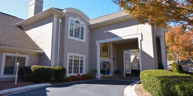 Exterior view of Regency House of Buford entrance with arches and manicured shrubs