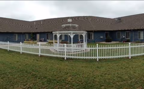Exterior view of Prairie Place Assisted Living with a white gazebo and white fence
