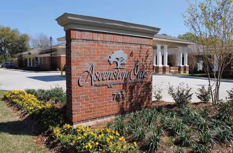Brick sign with Ascension Oaks logo and entrance to senior living facility