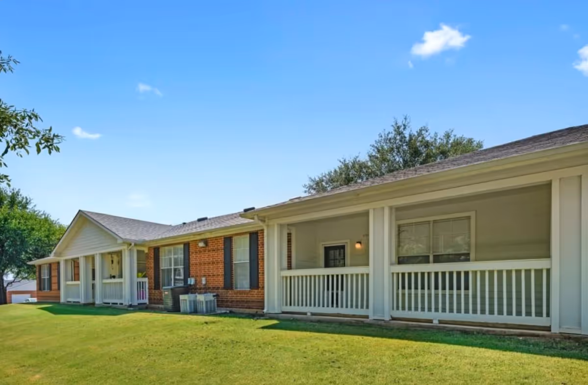 Single-story senior living facility with a covered front porch and green lawn.
