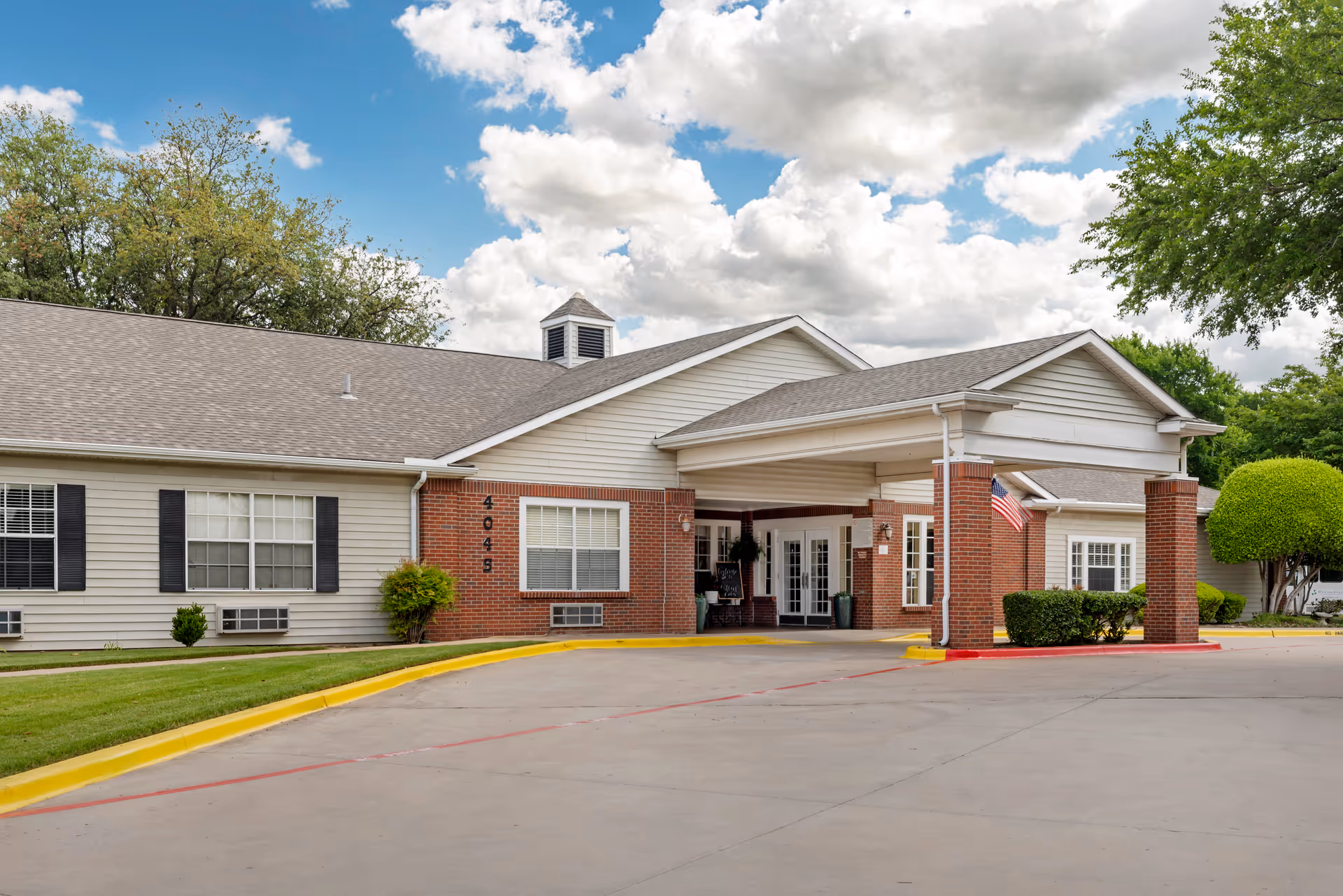 Exterior view of the Brookdale Collin Oaks senior living facility showing the entrance and surrounding landscape.