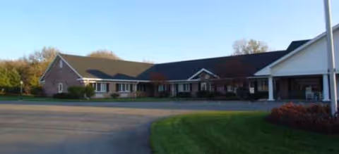 Front view of a single-story senior living facility with a curved driveway.