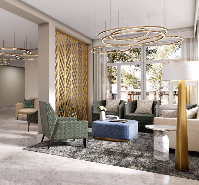 A modern and stylish living room area with green armchairs, a blue ottoman, beige sofas, a marble side table, and a tall floor lamp with a gold base. Large windows let in natural light and show trees outside. Circular pendant lights hang from the ceiling, and a decorative gold geometric panel is on one wall.