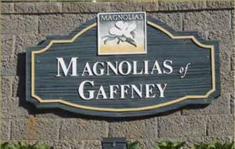 Exterior stone wall sign displaying Magnolias of Gaffney.
