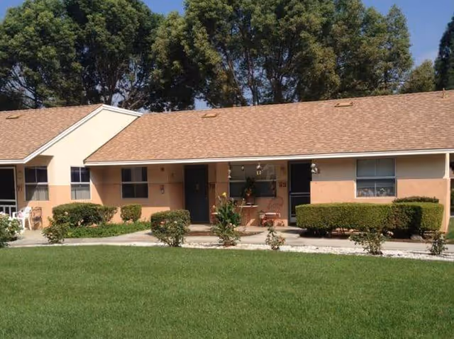 Single-story Harborview Apartments exterior with beige walls, brown roof, and manicured lawn.