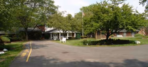 Exterior view of Brookdale Liverpool with driveway, trees, and front entrance.