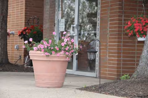 Front entrance of Eden Rehabilitation and Nursing Center with potted flowers and brick exterior.