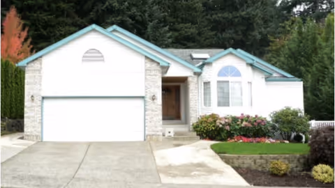 Front view of a single story senior living facility with a two car garage.