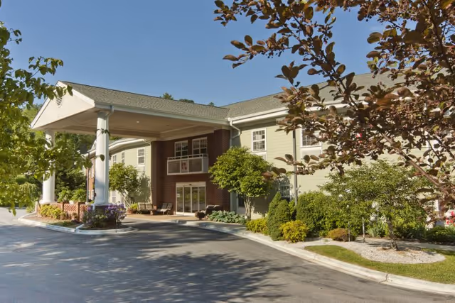 Exterior view of Mars Hill Manor's front entrance with a covered drop-off and landscaping.