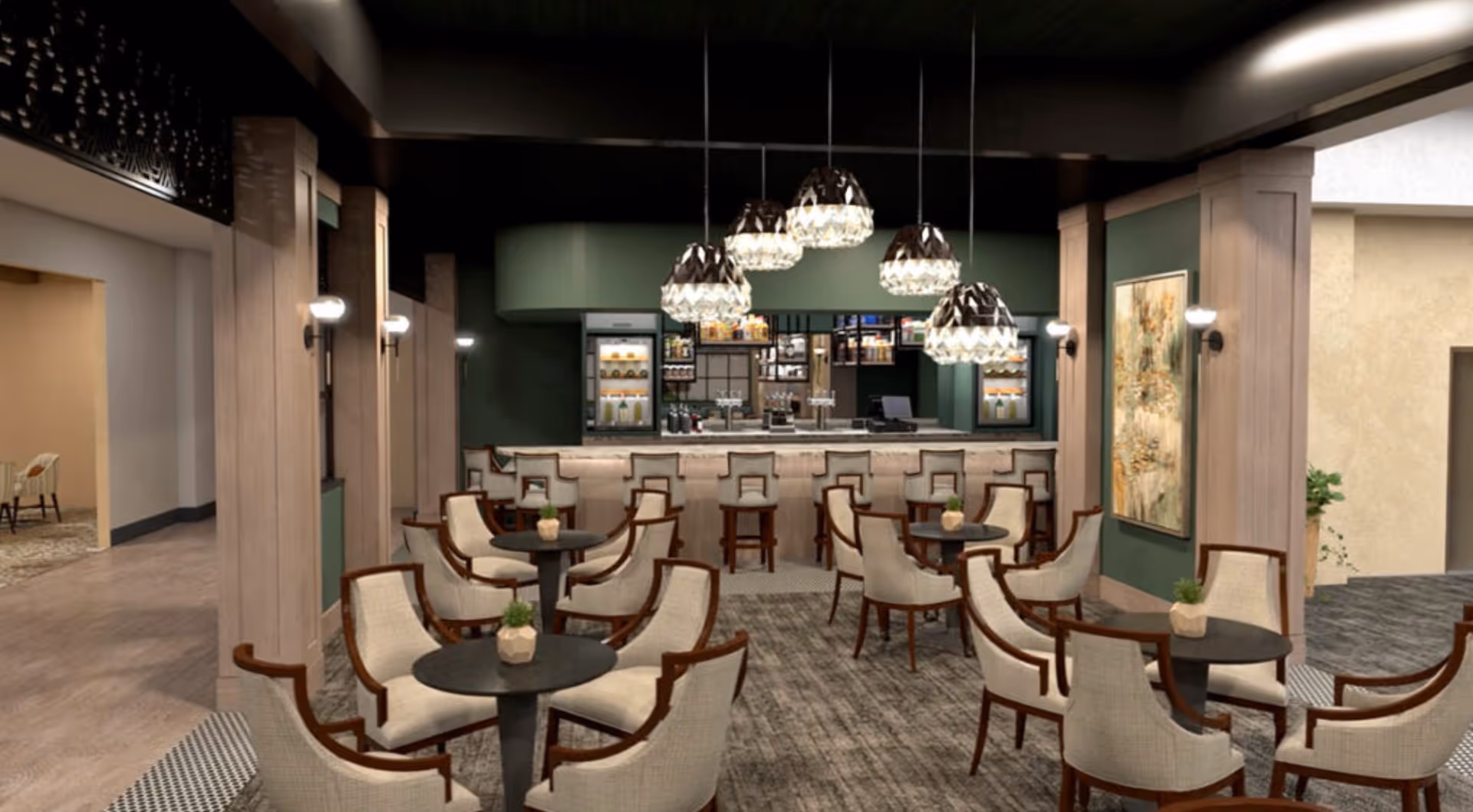 Interior view of a stylish dining area with multiple round tables surrounded by cushioned chairs. In the background, there is a bar counter with high stools and shelves stocked with beverages. Five decorative pendant lights hang from the ceiling above the bar. The walls are painted green with wooden panel accents and a large framed artwork is visible on the right side.