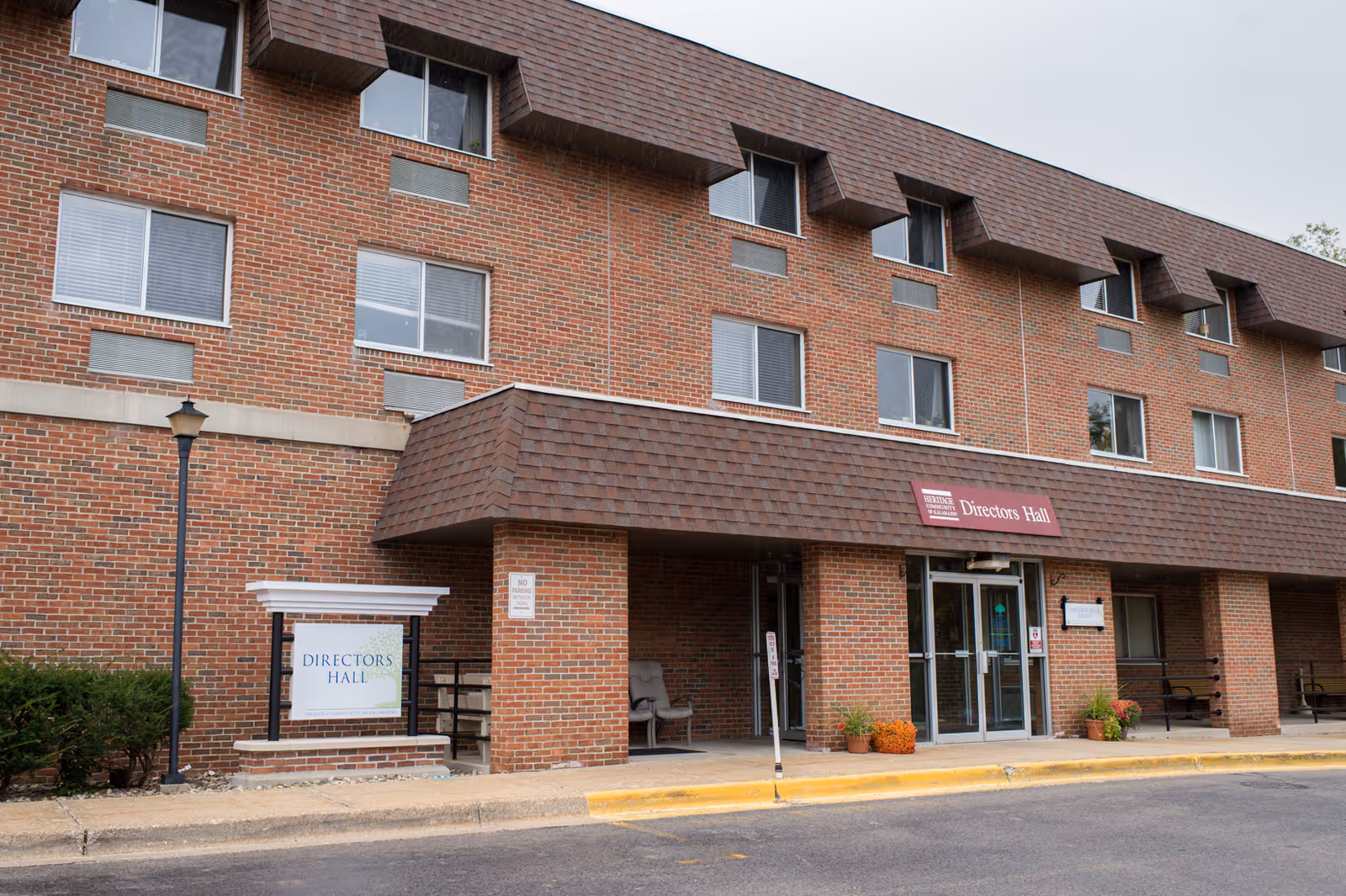 Brick senior living facility with a covered entrance labeled Directors Hall