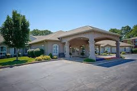 Exterior view of Bentleys Extended Care entrance with a covered porte-cochère and landscaping.