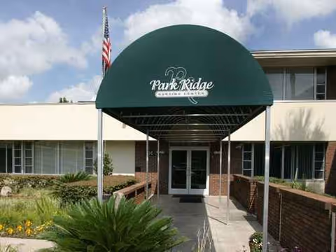 Front entrance of Park Ridge Nursing and Rehabilitation with green canopy and flag.