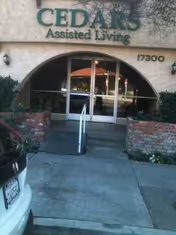 Entrance to Cedars Assisted Living with arched glass doors and ramp