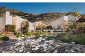 Exterior view of Carmel Valley Manor with white buildings and landscaped desert garden.