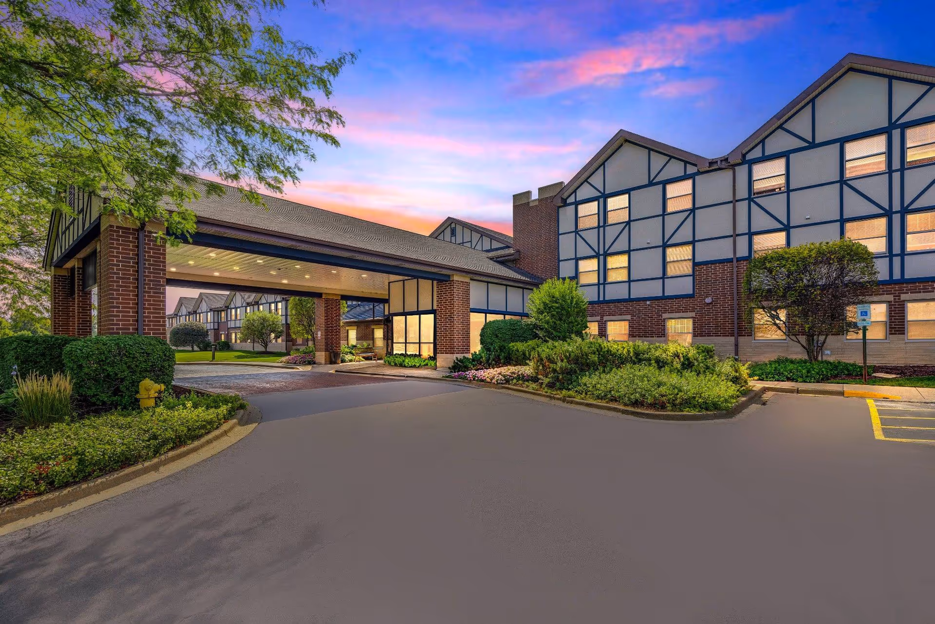 Sunrise of Olympia Fields exterior shows a brick-and-beam senior living building with a covered entrance.