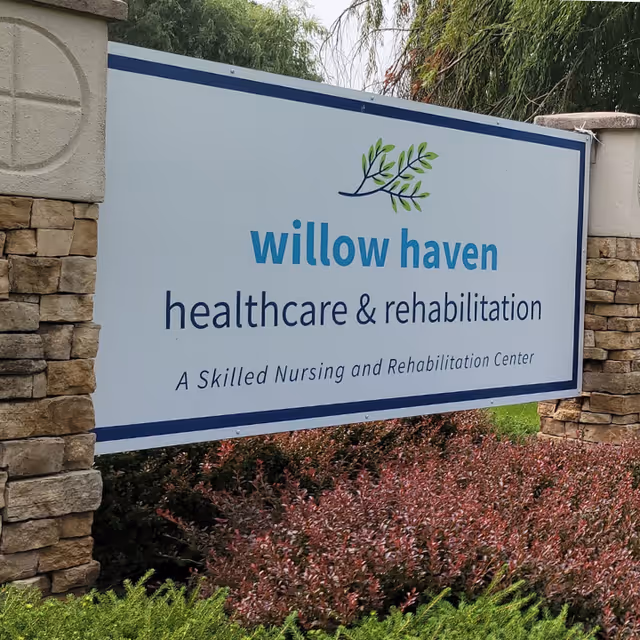 Outdoor entrance sign reading "willow haven healthcare & rehabilitation" mounted between stone pillars with landscaping in front.