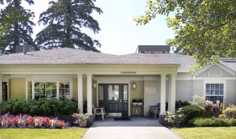 Exterior view of Farmington Square Tualatin entrance with flowers and shrubs