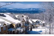 Snow-covered Wake Robin retirement community buildings line hillside with distant mountains.