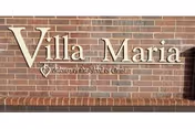Brick exterior wall with raised metal lettering reading "Villa Maria" and a smaller tagline beneath.
