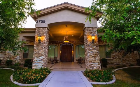 Entrance to Emerald Groves Central with stone pillars and a covered front porch.