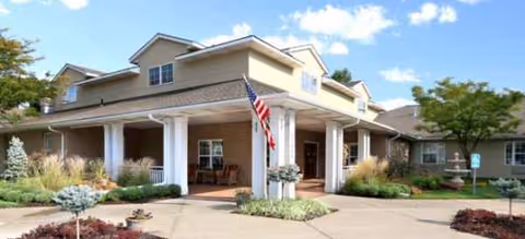 Front exterior view of Brookdale Shawnee with a covered entrance, columns, and landscaped grounds.