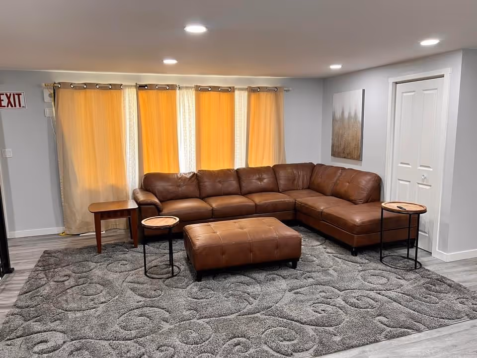 Brown leather sectional sofa with ottoman in a cozy living room lounge.