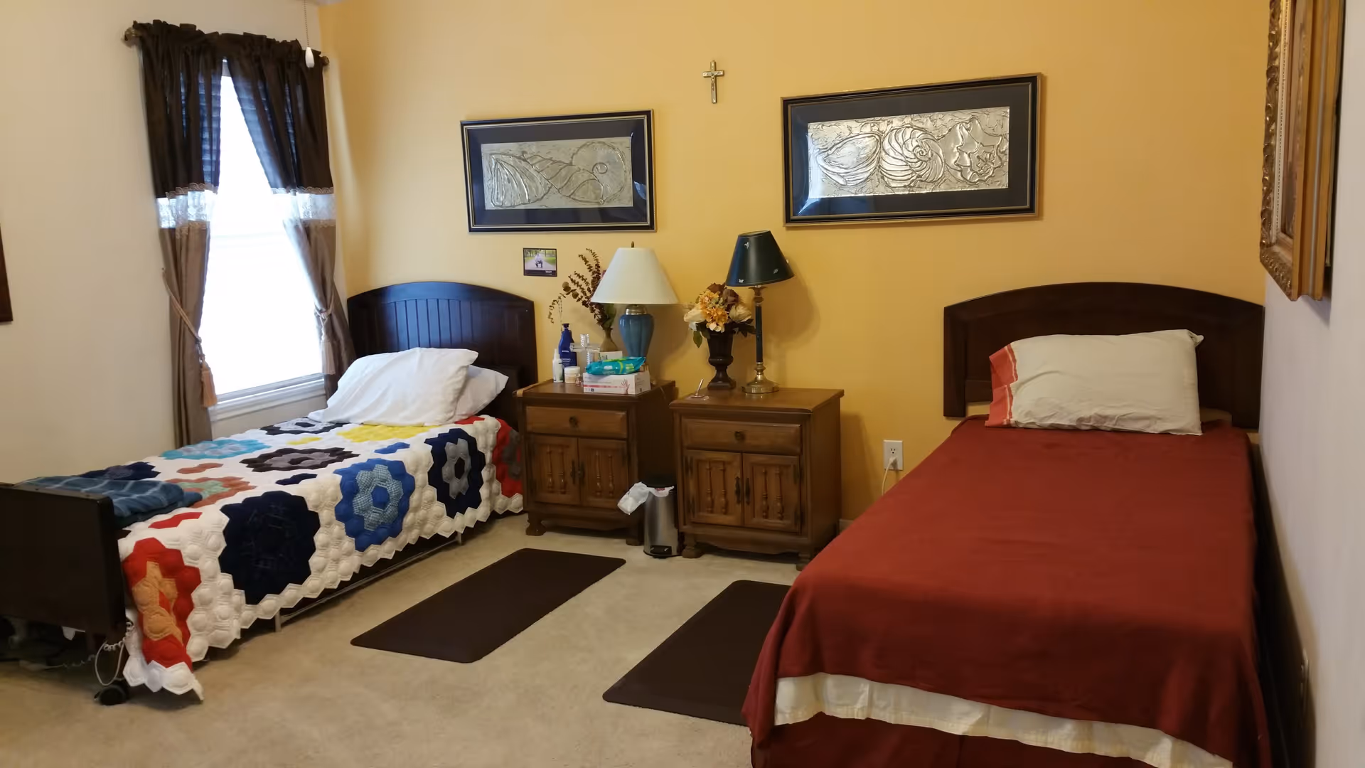 A cozy bedroom with two single beds, nightstands with lamps, and framed artwork on a yellow wall.