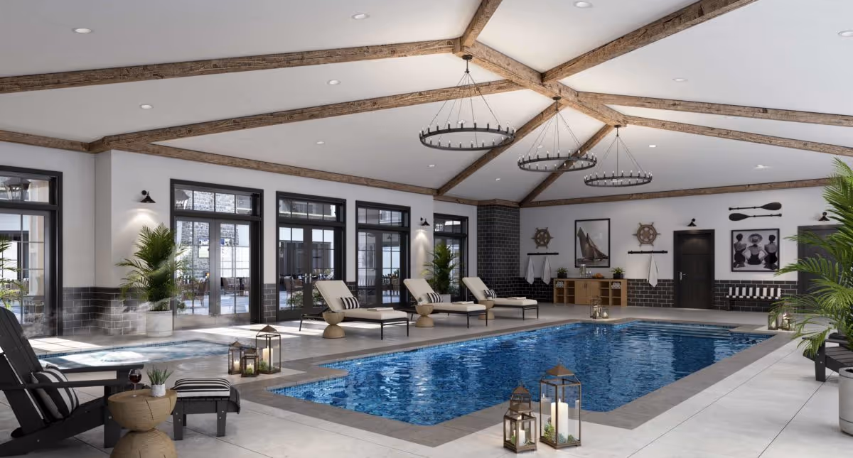 Indoor swimming pool area with lounge chairs, potted plants, and decorative lanterns around the pool. The ceiling has exposed wooden beams and circular chandeliers. Large windows and glass doors line the walls, allowing natural light to enter the space. Nautical-themed wall decorations and a seating area are visible in the background.