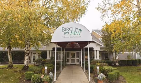Entrance to Birchview Memory Care with a covered walkway and landscaped grounds.