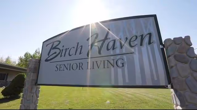 Outdoor entrance sign reading Birch Haven Senior Living beside stone pillars.