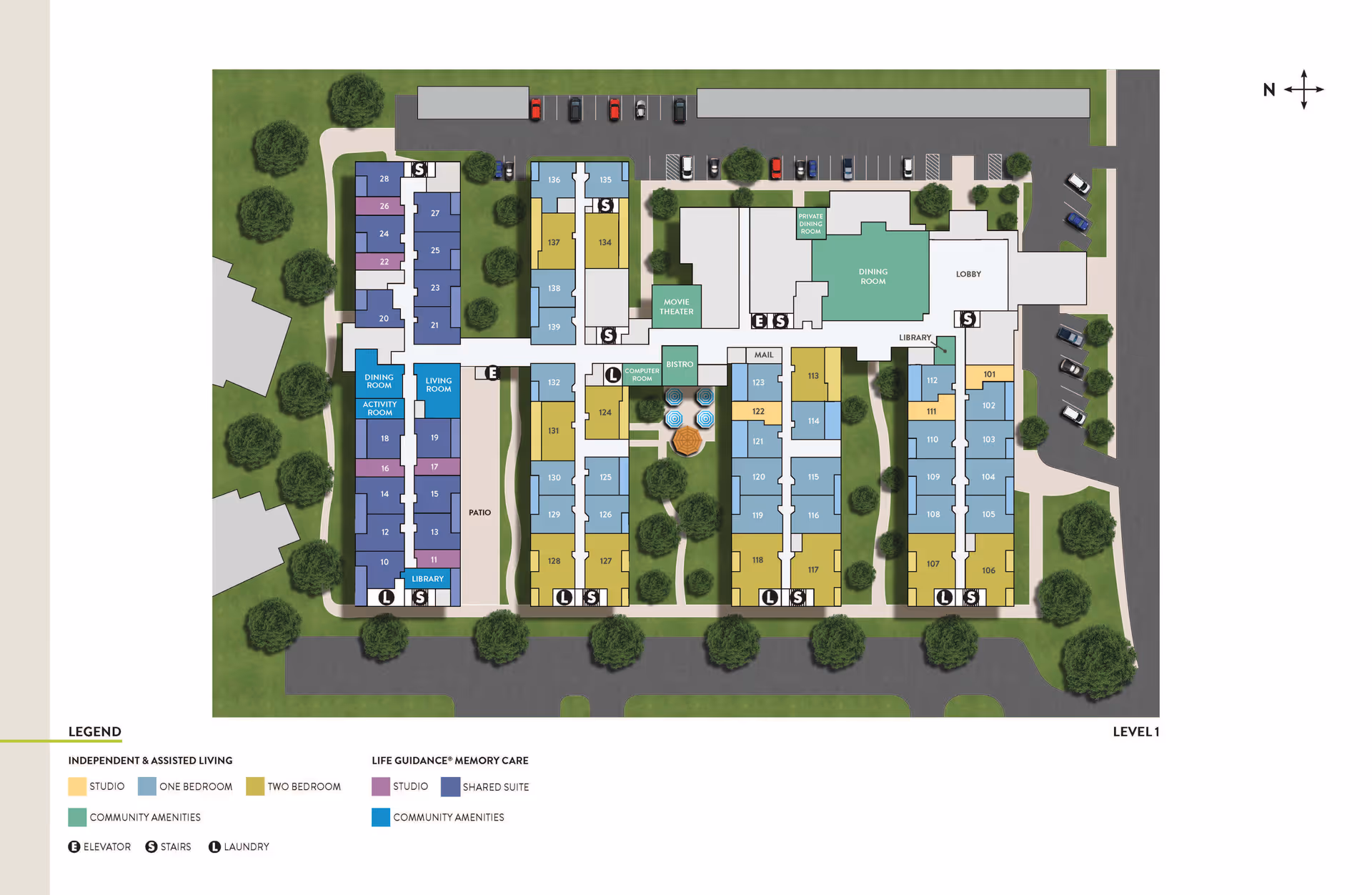 Floor plan of Atria Covell Gardens senior living facility showing various rooms and amenities including dining rooms, activity room, living room, library, movie theater, private dining room, mail area, computer room, and bistro. The plan is color-coded to indicate independent & assisted living studios, one-bedroom, two-bedroom units, life guidance memory care studios, shared suites, and community amenities. Elevators, stairs, and laundry areas are also marked. Surrounding the building are parking areas and green spaces with trees.