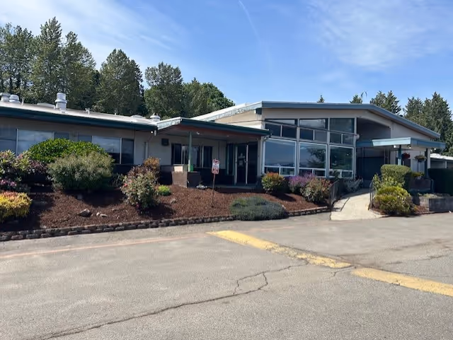 Exterior view of the Renton Health and Rehabilitation facility surrounded by greenery.