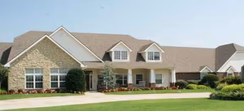 Single-story building with stone facade, well-kept lawn, and front entrance.