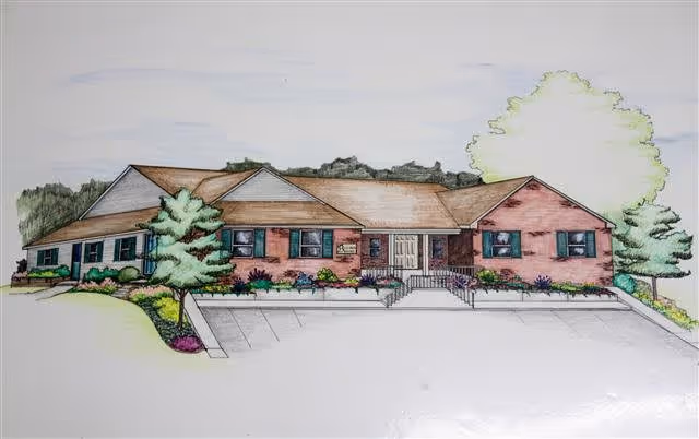 Colored architectural drawing of a single-story brick assisted living building front with parking spaces, entrance steps, and landscaped shrubs and trees.