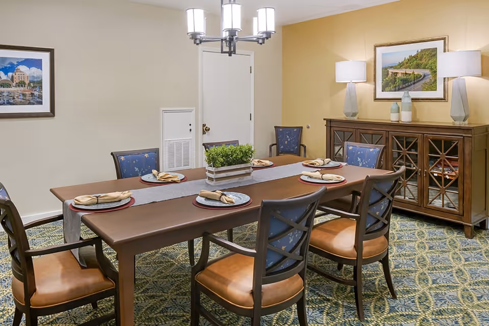 A dining room with a large table, chairs, and decorative elements.