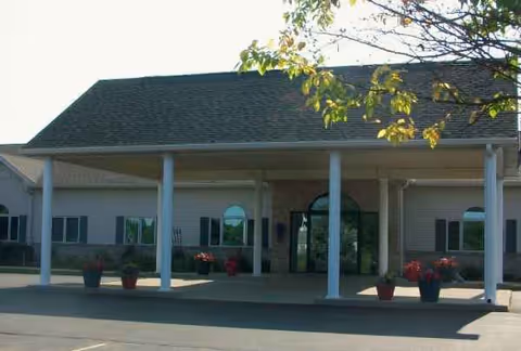 Front view of Eastland Retirement Community entrance with columns and potted plants.