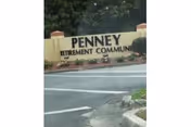 Exterior view of a Penney Retirement Community entrance sign beside the driveway.