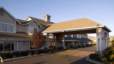 Exterior view of Atria Summit Ridge senior living facility with a covered entrance.