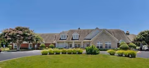 Brick building of Brookdale Georgetown with manicured lawn, shrubs, and a clear blue sky.