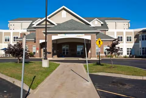 Front view of Wayne County Nursing Home entrance with a covered porte-cochere and curved driveway.