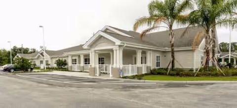 Front view of Brookdale Highlands senior living facility with palm trees and a parking lot
