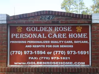 Brick exterior sign displaying Golden Rose Personal Care Home name and contact information.