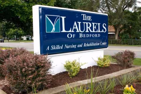 Exterior sign reading The Laurels of Bedford with surrounding landscaping