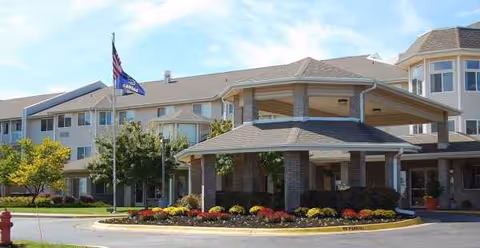 Exterior view of Holiday Thornton Place with a covered entrance and landscaped front entry.