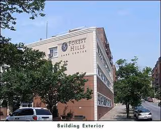Exterior view of Forest Hills Care Center with trees and parked cars.
