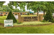 Brick entrance sign reading 'HIGHLAND HEALTH CARE' in front of a single-story care facility with trees and a manicured lawn.