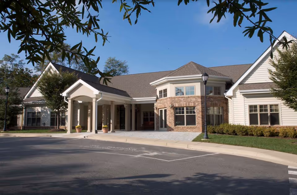 Exterior view of The Sylvestery at Vinson Hall retirement community entrance with a covered front porch.