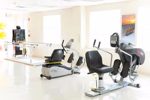 Bright gym area at Beach Terrace Care Center with cardio machines and exercise equipment.